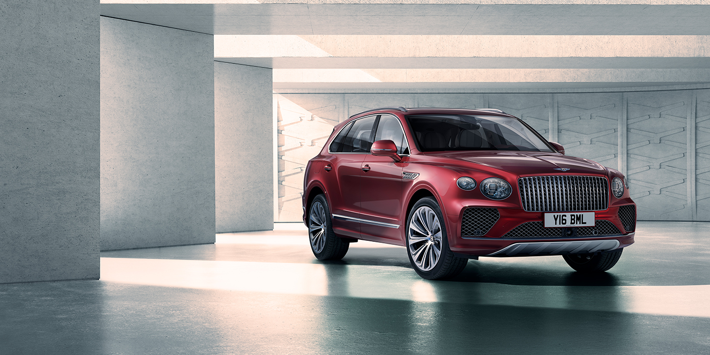 Bentley Riyadh Bentley Bentayga Atelier Edition SUV in Rubino Red paint front three quarter against textured concrete wall