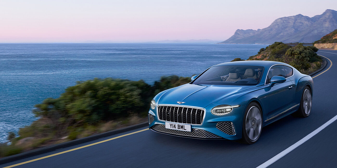 Bentley Riyadh New Bentley Continental GT Azure coupe in Light Windsor blue paint with 22 inch Azure wheels and chrome grill, driving dynamically by the se