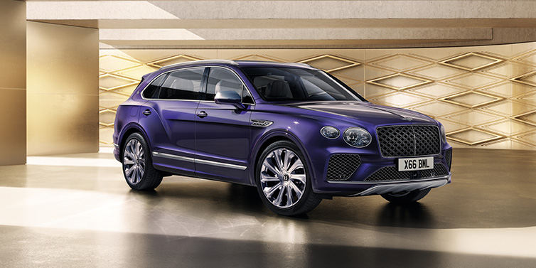 Bentley Riyadh Bentley Bentayga Extended Wheelbase Mulliner SUV front three quarter in Tanzanite Purple paint with a gold patterned background