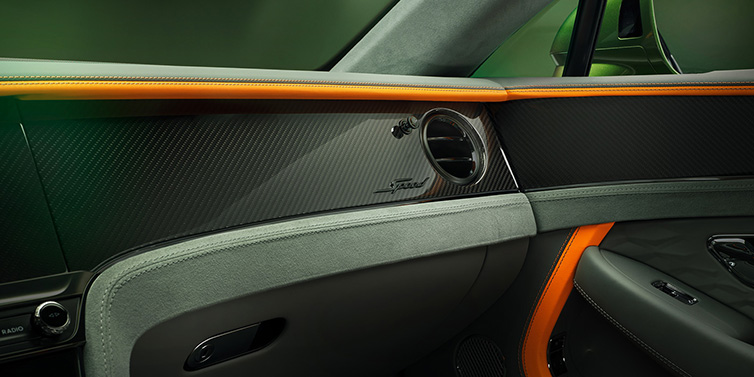 Bentley Riyadh Bentley Continental GT Speed coupe front interior dash detail with high gloss carbon fibre veneer surrounded by Mandarin by Mulliner and Gravity Grey hides