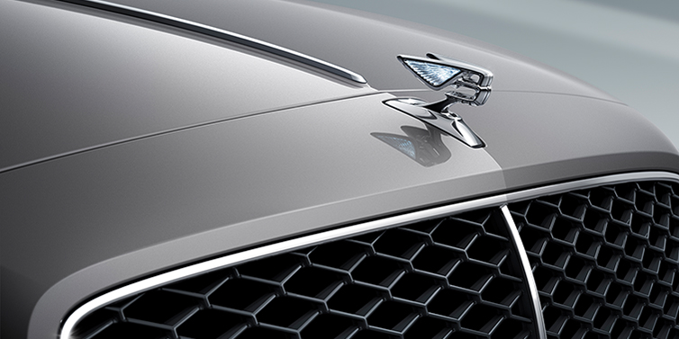 Bentley Riyadh New Bentley Flying Spur sedan bonnet detail in Silverlake paint with Illuminated Flying B bonnet badge and matrix grille with chrome surround