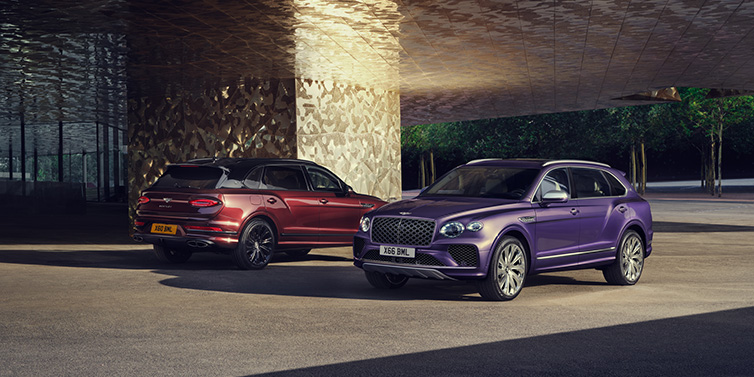 Bentley Riyadh A duo of Bentley Bentayga Extended Wheelbase Mulliner SUVs parked in a city environment, with Tanzanite Purple and Cricket Ball red exterior paint