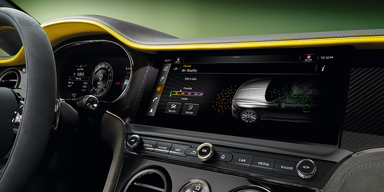 Bentley Riyadh Bentley Continental GTC Speed convertible front interior centre console with MMI screen showing Air Quality visualisation surrounded by Cyber Yellow by Mulliner and Gravity Grey hides and high gloss carbon fibre veneer