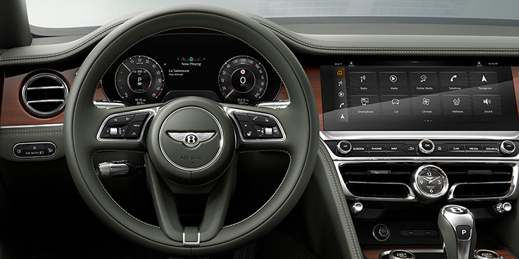 Bentley Riyadh New Bentley Flying Spur front cabin interior in Cumbrian green hide with Crown Cut walnut veneer showing steering wheel and driver controls