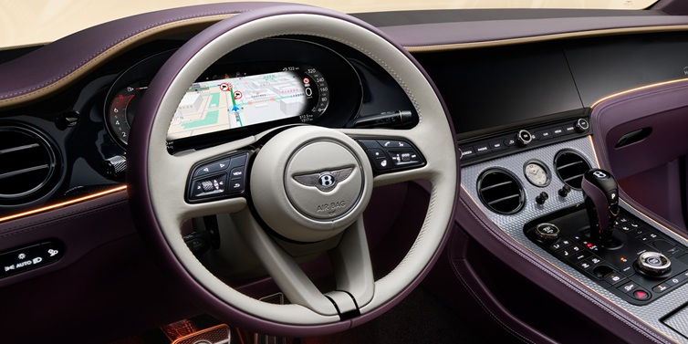 Bentley Riyadh Bentley Continental GT Mulliner coupe front interior showing steering wheel and drivers screens surrounded by Linen and Damson hides and Grand Black veneer